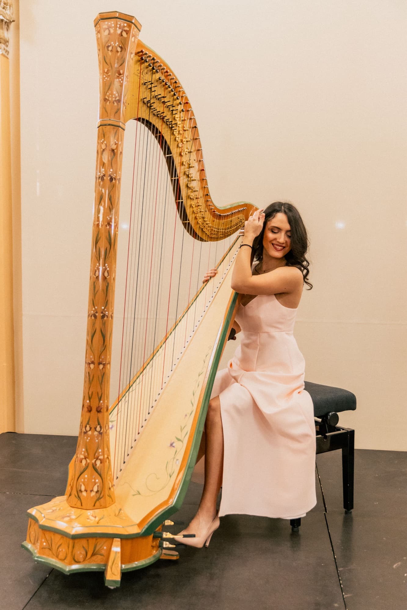 Irina posing with her harp on stage
